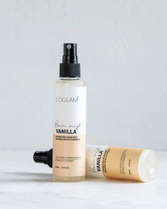 L’OGLAM Vanilla hair mist bottles on white surface, one standing and one lying down