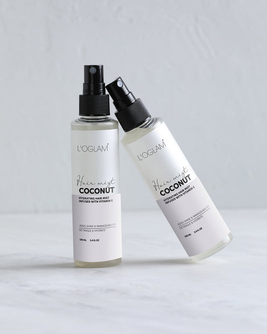 L’OGLAM Coconut Hair Mist bottles on white surface; one upright and one leaning